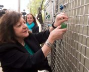 Woman hanging lock on Philadelphia Hope Fence